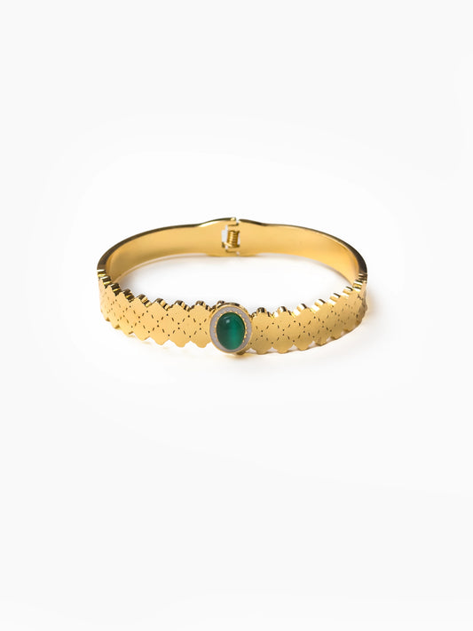 Gold ring with a green gemstone on a white background